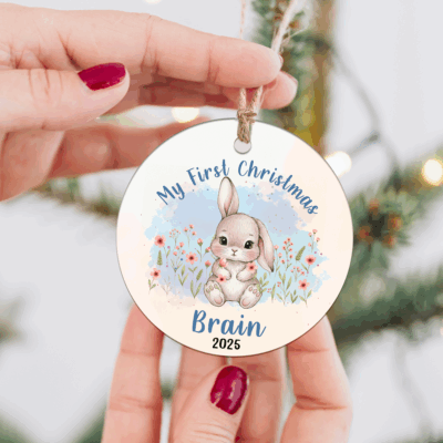 Personalized Bunny Baby First Christmas Ornament featuring a cute bunny in a pink dress with flowers, custom name Cadie 2025, that perfect keepsake decoration for a baby girl’s first Xmas.