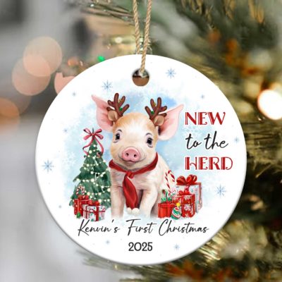 Personalized baby’s first Christmas ornament featuring a cute piglet wearing reindeer antlers and red scarf, surrounded by a Christmas tree, presents, and text New to the Herd, customized with baby’s name and year.