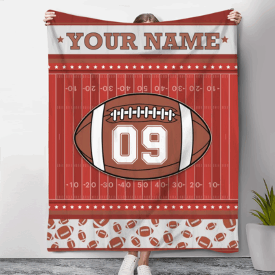 Personalized Football Blanket with customizable name and jersey number, designed to look like a football field with a large football graphic in the center. Available in multiple color options, with decorative football patterns along the border, making it a cozy and unique gift for football players and fans.