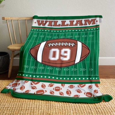 Personalized Football Blanket with customizable name and jersey number, designed to look like a football field with a large football graphic in the center. Available in multiple color options, with decorative football patterns along the border, making it a cozy and unique gift for football players and fans.