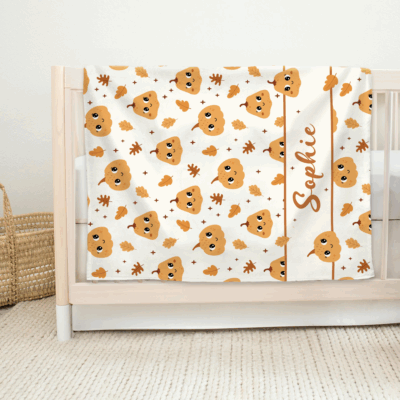 Personalized pumpkin baby blanket with name, custom fall baby shower gift, toddler Thanksgiving blanket, and autumn nursery bedding.