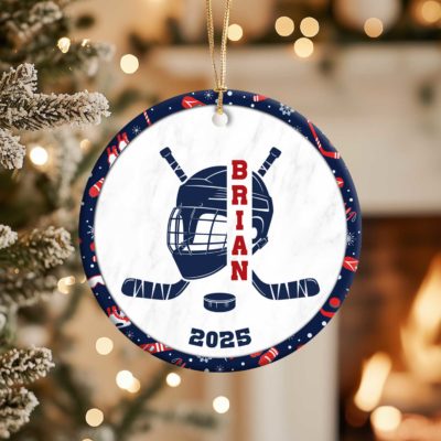 Personalized Hockey Ornament - Sport Gift for Player featuring a helmet, crossed sticks, and puck design with customizable name and year, hanging on a Christmas tree - perfect Christmas gift for hockey players and fans.