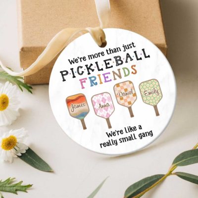 Personalized Pickleball Ornament - Sport Gift for Pickleball Lover featuring colorful paddles with custom names and the quote ‘We’re more than just pickleball friends, we’re like a really small gang,’ hanging on a Christmas tree, the perfect gift for pickleball lovers and friends.