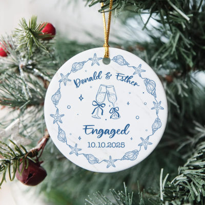Personalized Beach Engaged Ornament - Gift For Newly Engaged with seashell and starfish design, featuring couple’s names, engagement date, and champagne glasses illustration, hanging on Christmas tree as an engagement keepsake gift.
