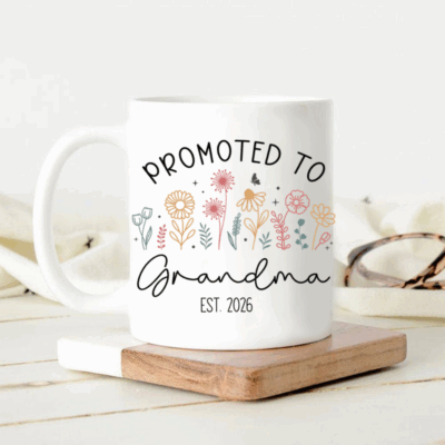 Custom Promoted to Grandma Coffee Mug - Gift for Grandma with “Promoted to Grandma” text and colorful floral design, displayed on a table as a pregnancy announcement gift for first-time grandma