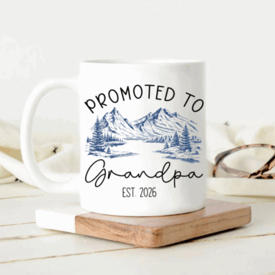 Custom Promoted to Grandpa Coffee Mug with “Promoted to Grandpa Est” text and mountain landscape design, held in hands outdoors as a gift for first-time grandpa