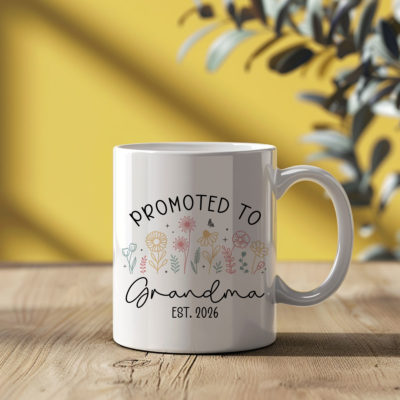 Custom Promoted to Grandma Coffee Mug - Gift for Grandma with “Promoted to Grandma” text and colorful floral design, displayed on a table as a pregnancy announcement gift for first-time grandma