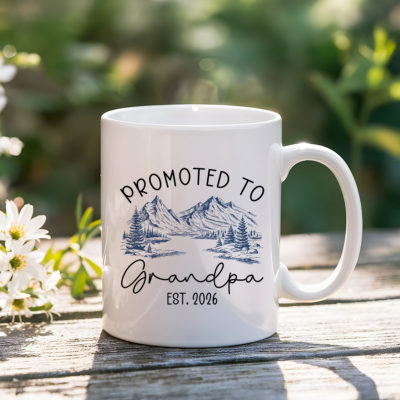Custom Promoted to Grandpa Coffee Mug with “Promoted to Grandpa Est” text and mountain landscape design, held in hands outdoors as a gift for first-time grandpa