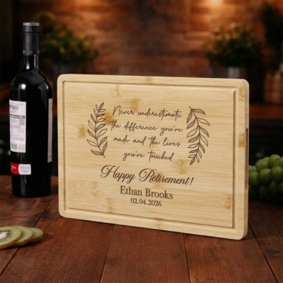 Retirement Personalized Cutting Bamboo Board - Happy Retirement Gift engraved with retirement message, name, and date, surrounded by kitchen items, used as a farewell gift for coworker