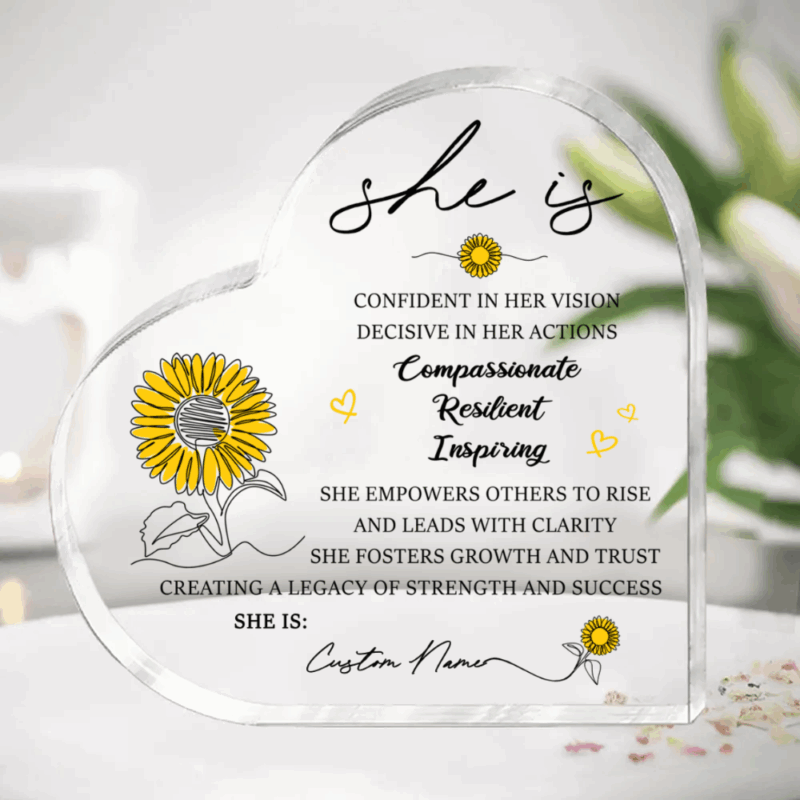Personalized She Is Heart Acrylic Plaque featuring a custom name, sunflower illustrations, and inspirational affirmations celebrating confidence, resilience, compassion, and leadership, designed as an appreciation gift for women and coworkers.